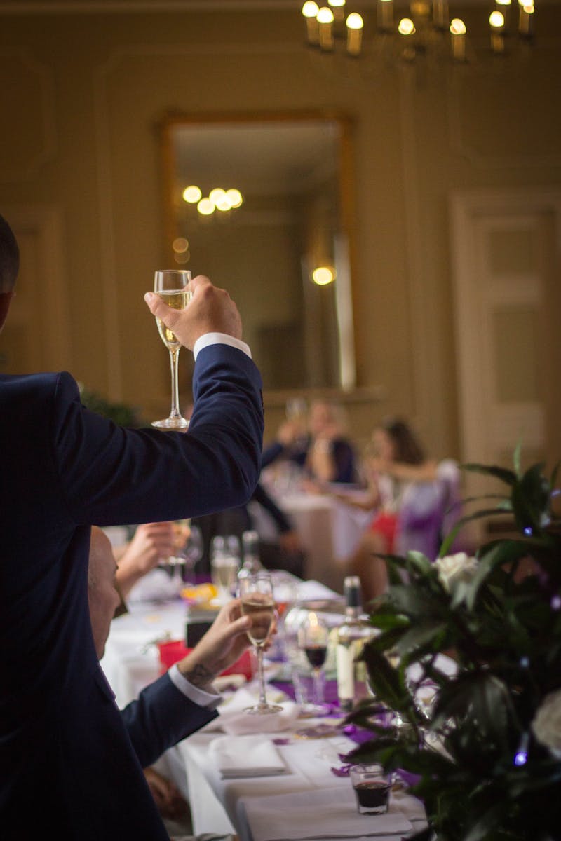 A formal gathering with people toasting with champagne in an elegant indoor setting.